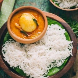 idiyappam or rice string hoppers served on wooden plate with egg stew