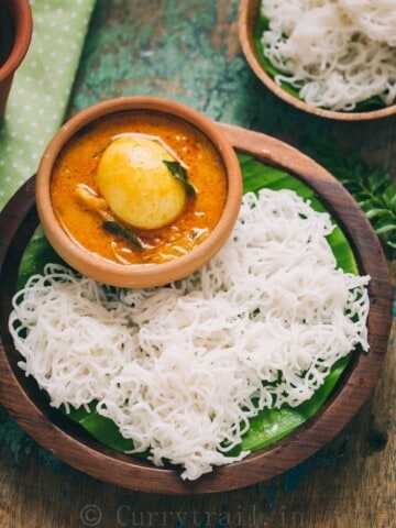 idiyappam or rice string hoppers served on wooden plate with egg stew