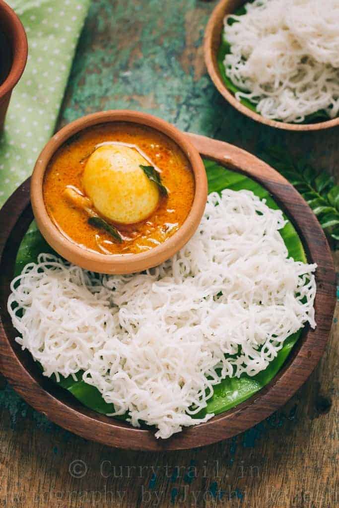 idiyappam or rice string hoppers served on wooden plate with egg stew 