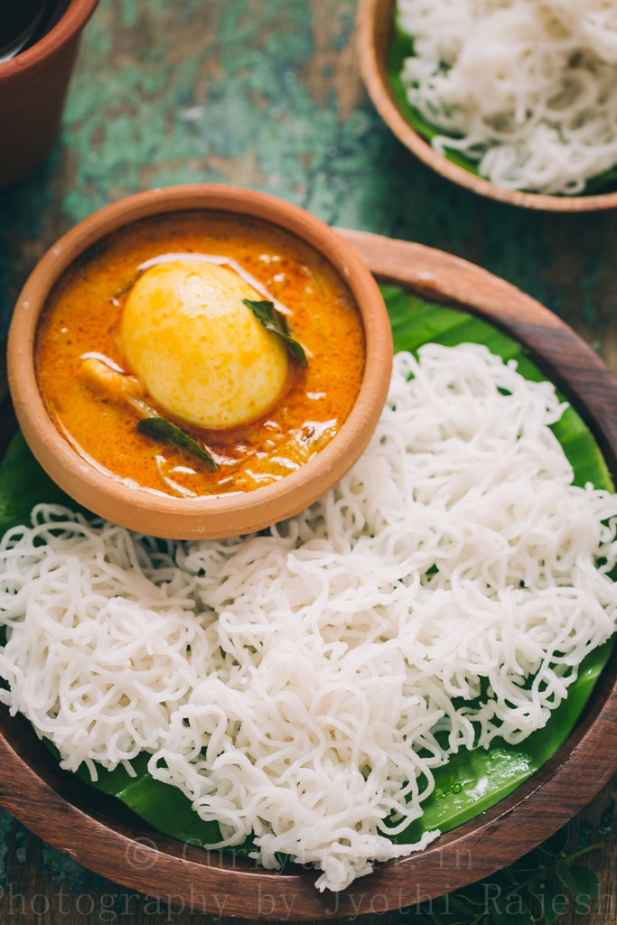 idiyappam or rice string hoppers served on wooden plate with egg stew