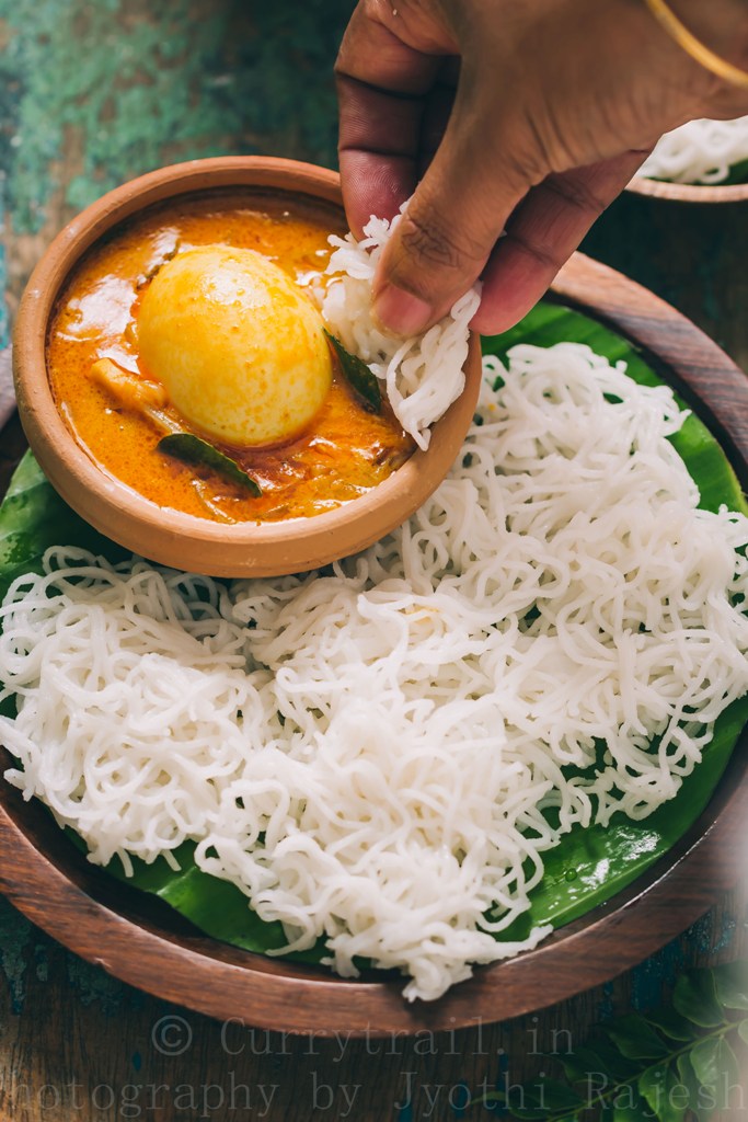 idiyappam or rice string hoppers served on wooden plate with egg stew 