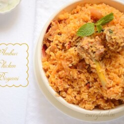 Ambur chicken biryani in a white bowl with chicken leg piece and boiled egg on top