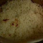 cooked jeera rice is layered over ambur chicken biryani masala