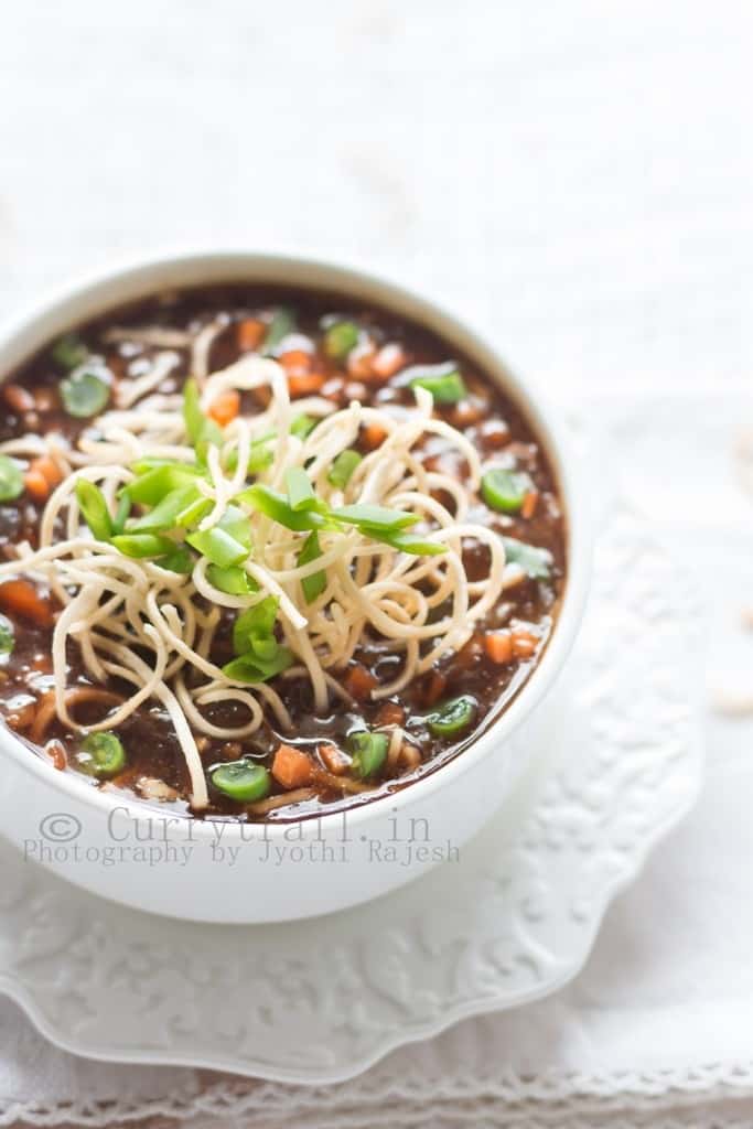 hot sour and spicy vegetable manchow soup topped with crunchy fried noodles served in white bowl