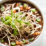 hot sour and spicy vegetable manchow soup topped with crunchy fried noodles served in white bowl