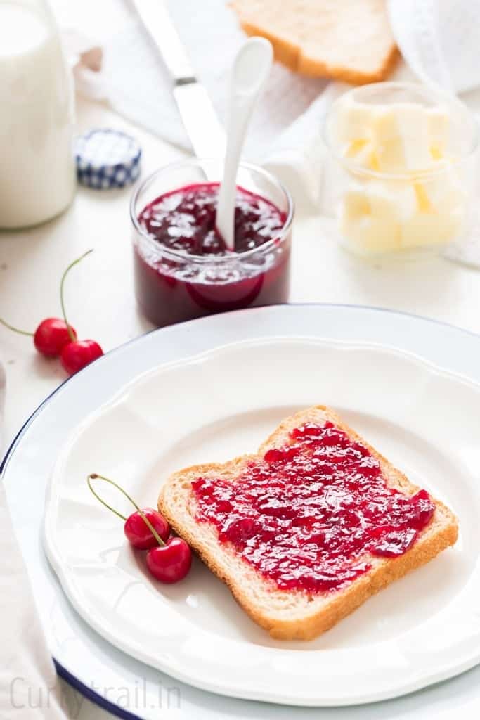 slice of bread smeared with homemade cherry jam 