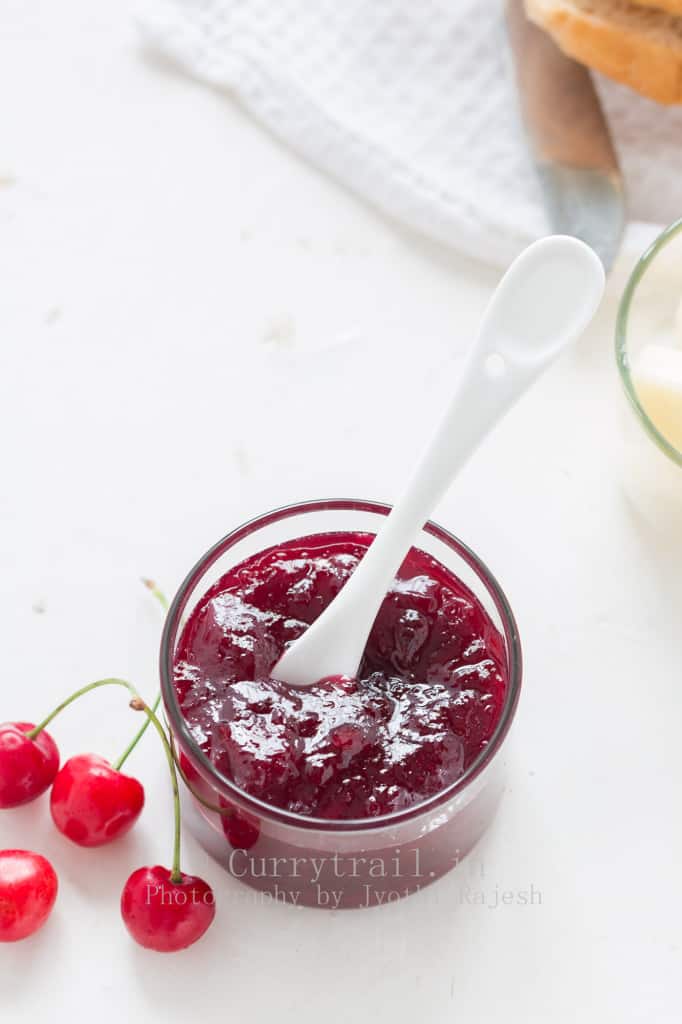 cherry jam made without pectin served in glass bowl with fresh cherries on sides