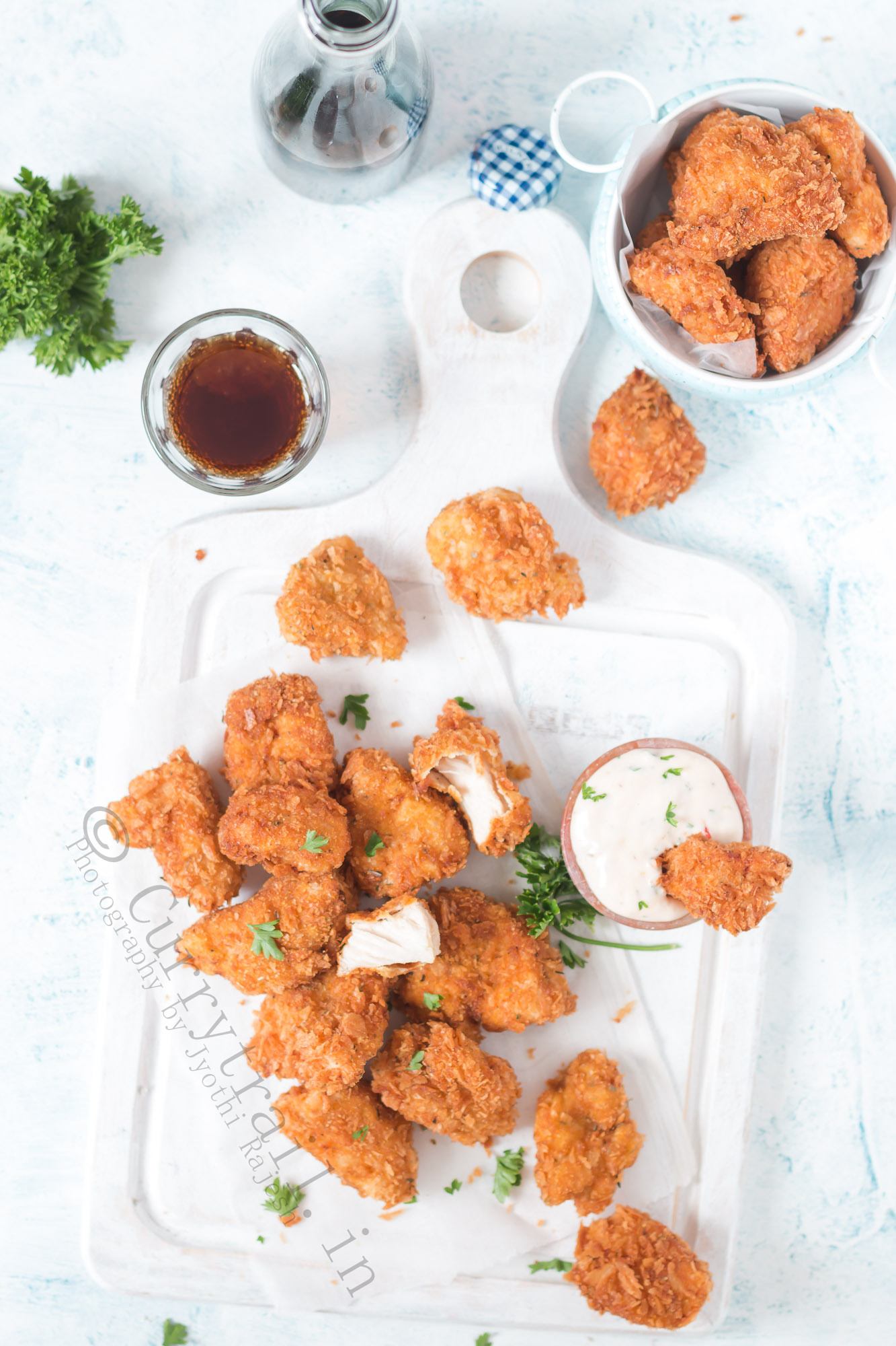 homemade chicken nuggets server on white tray with creamy spicy sauce on the side