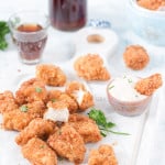 homemade chicken nuggets server on white tray with creamy spicy sauce on the side