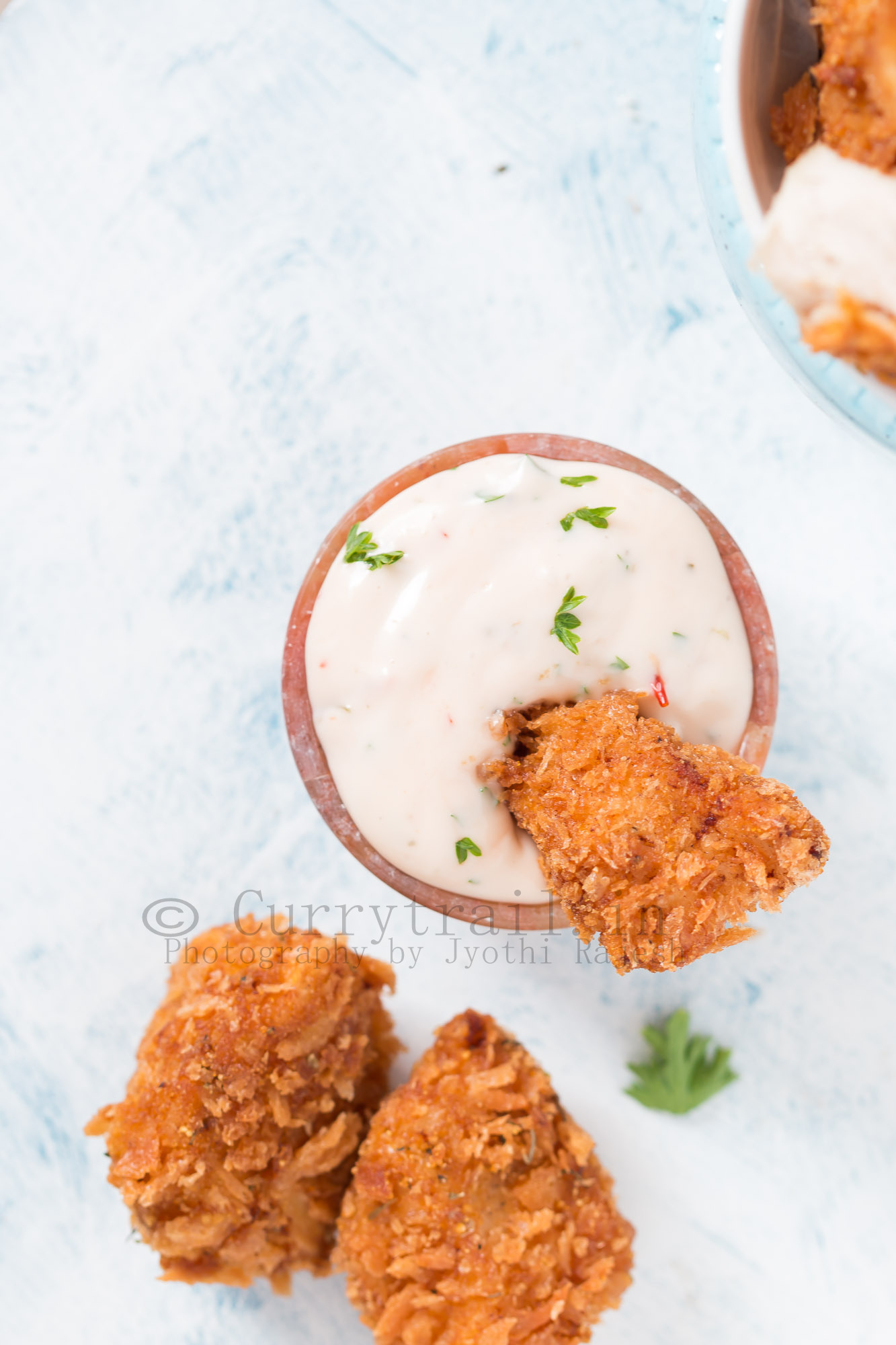 homemade chicken nuggets server on white tray with creamy spicy sauce on the side