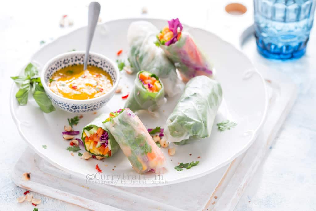 Thai rice paper rolls with mango dipping sauce in white plate