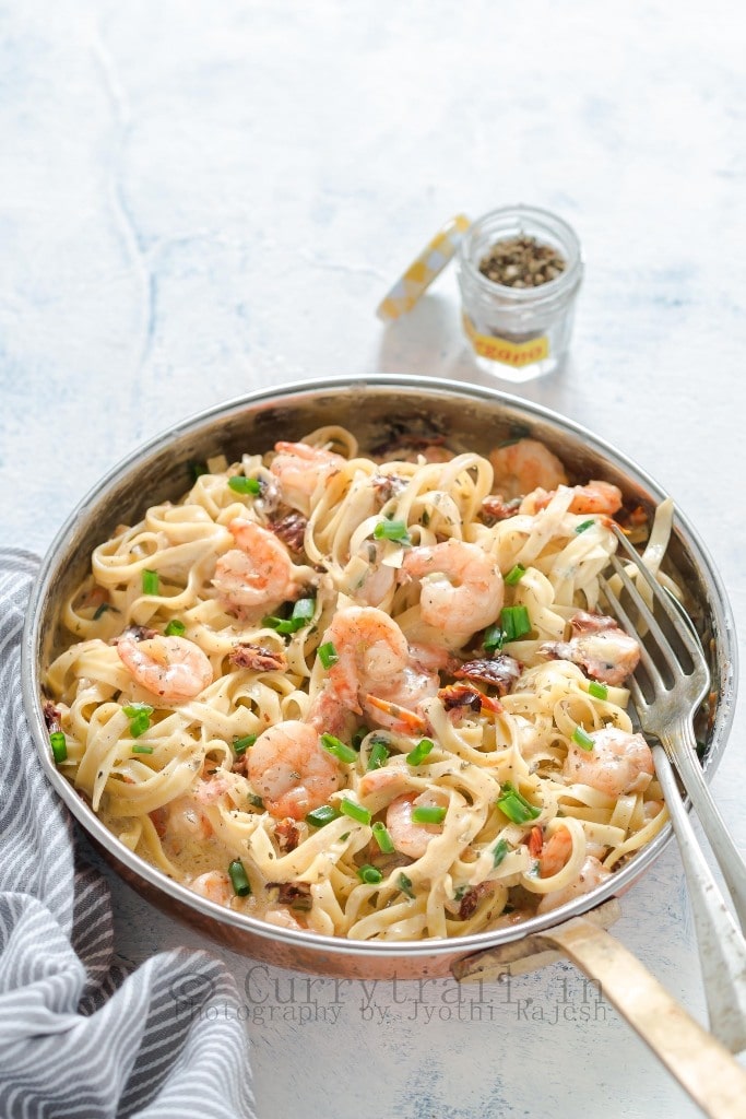 Garlic Shrimp Pasta in Creamy Sauce In a Pan and seasoning bottle