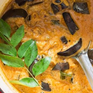 healthy brinjal curry in pot with fresh curry leaves