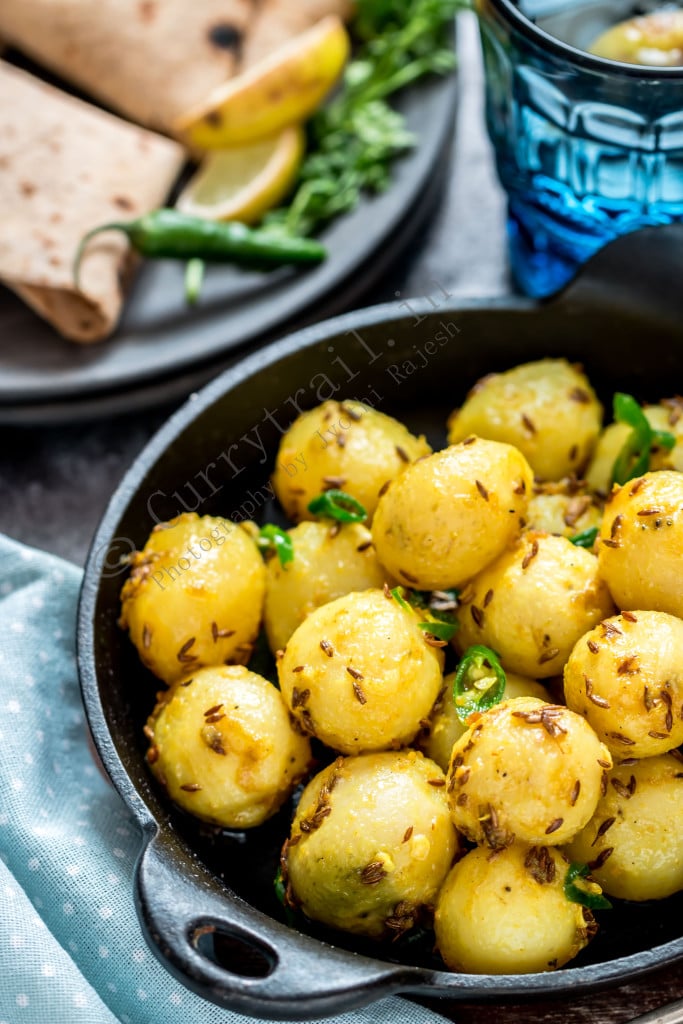 Jeera aloo in black cast iron pan with rotis on side