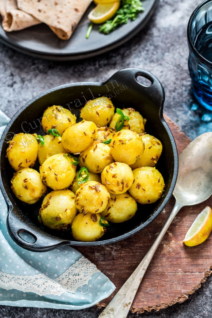 Jeera aloo in black cast iron pan and a spoon