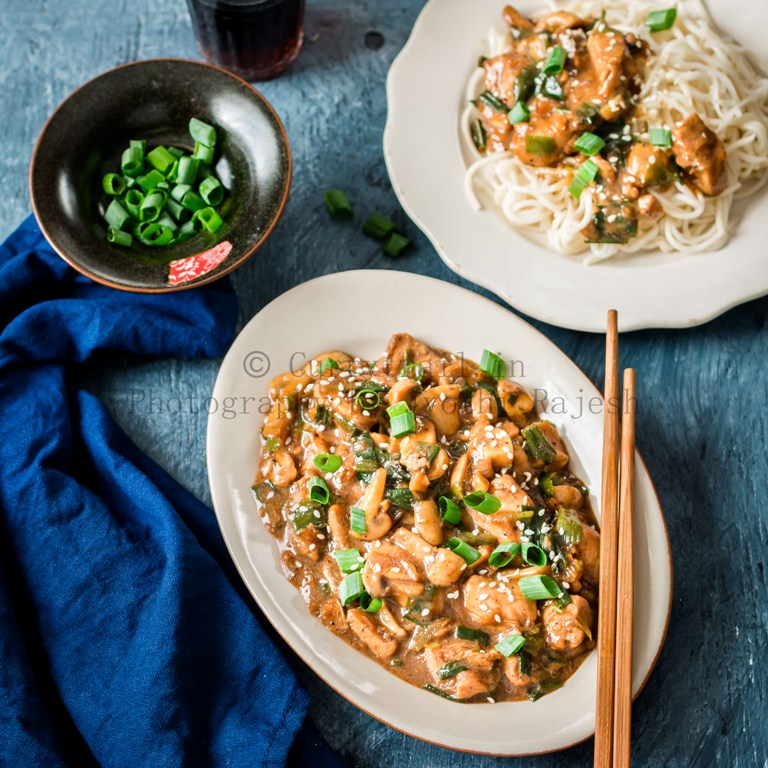 cantonese chicken with mushrooms served in white oval ceramic plate with chopsticks