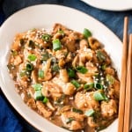 cantonese chicken with mushrooms served in white oval ceramic plate with chopsticks