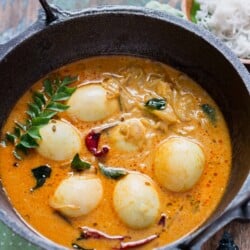 egg stew Kerala style served in cast iron pan for breakfast with rice string hoppers