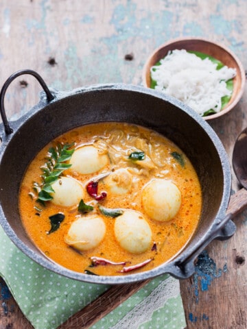 egg stew Kerala style served in cast iron pan for breakfast with rice string hoppers