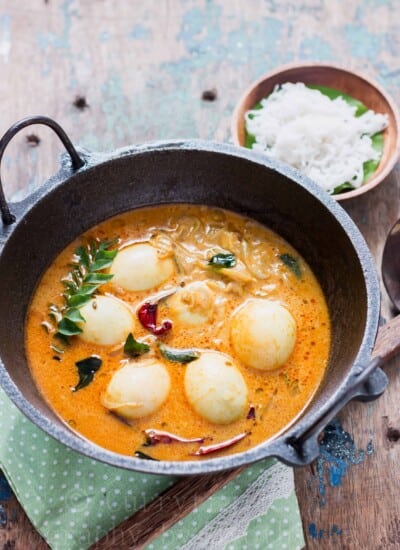 egg stew Kerala style served in cast iron pan for breakfast with rice string hoppers