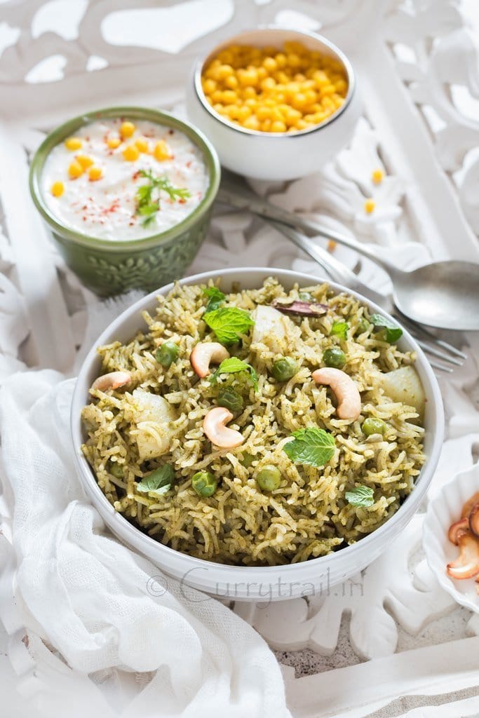 Homemade Mint Pulao in white bowl with raita on the side