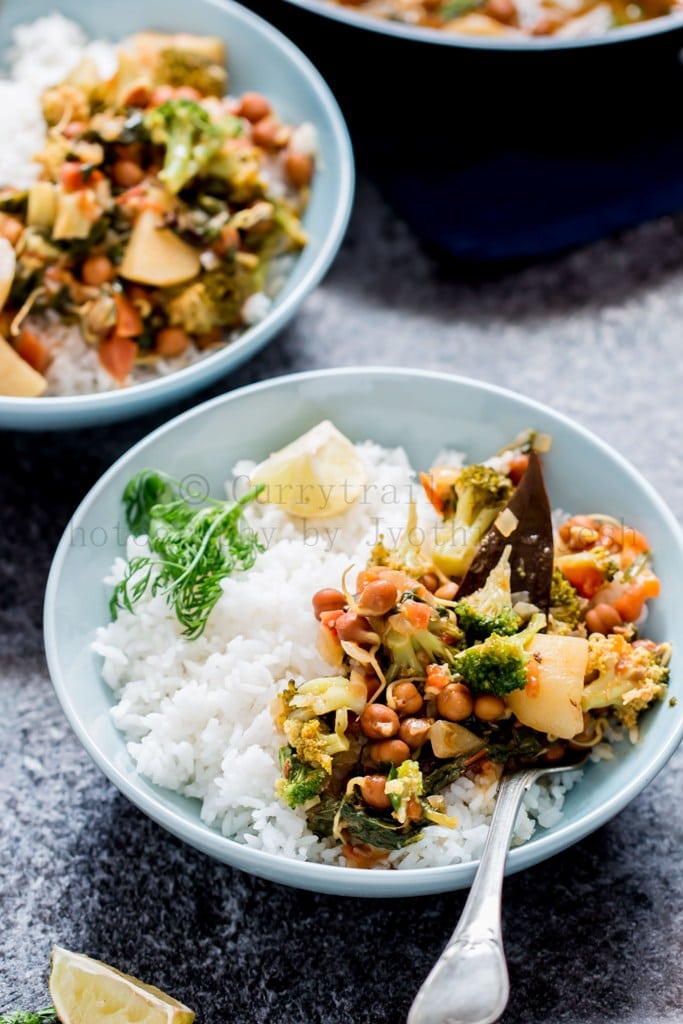 Blue bowl of rice with vegetable chickpea curry on top