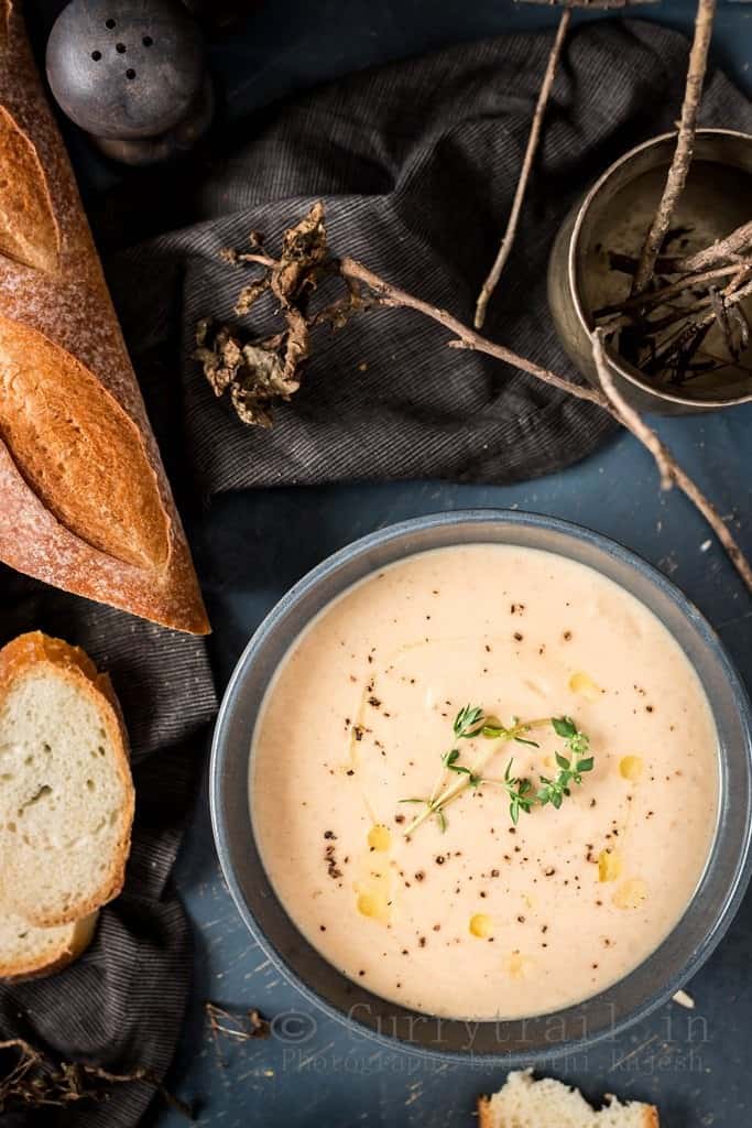 spiced roasted cauliflower soup served in ceramic bowls with French baguette bread to dip in 