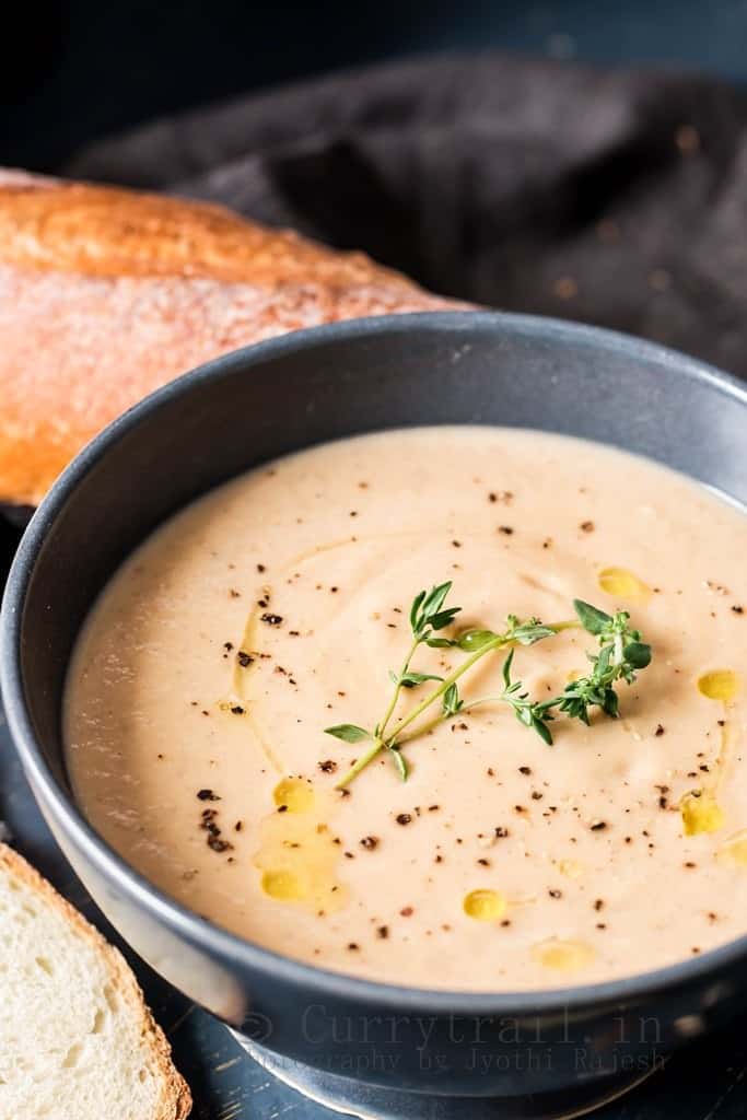 spiced roasted cauliflower soup served in ceramic bowls with French baguette bread to dip in 