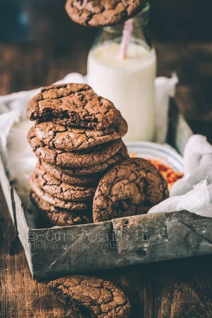 dark chocolate chili cookies served in rustic tray with bottle of milk on the side