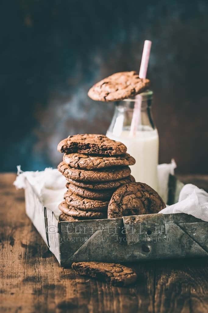 dark chocolate chili cookies served in rustic tray with bottle of milk on the side