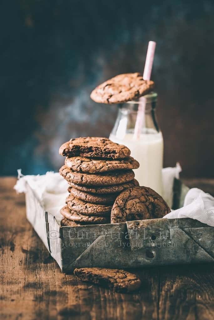 dark chocolate chili cookies served in rustic tray with bottle of milk on the side