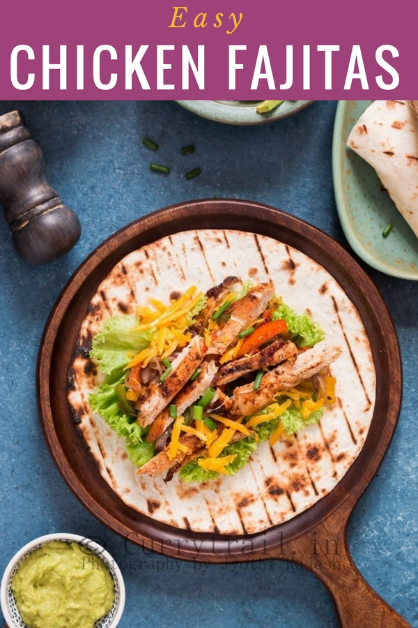 Chicken fajita spread on tortillas on a wooden plate