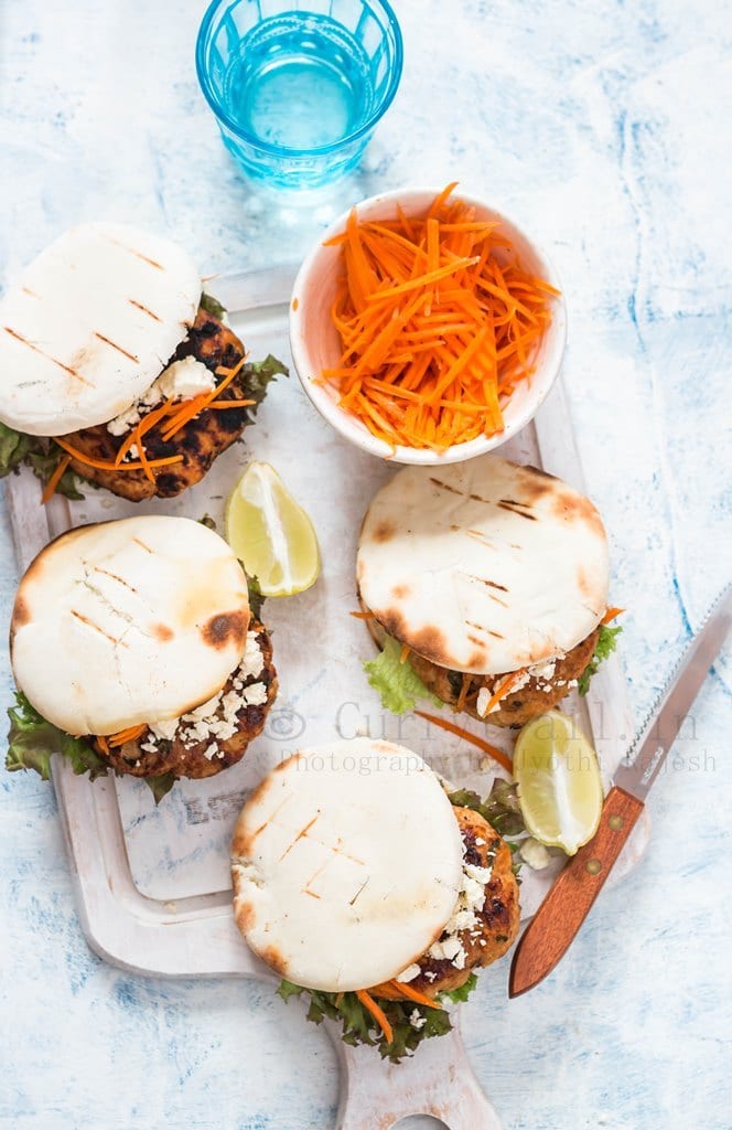 Moroccan Chicken Burgers Spread on a Boards with Bowl of carrots in top view