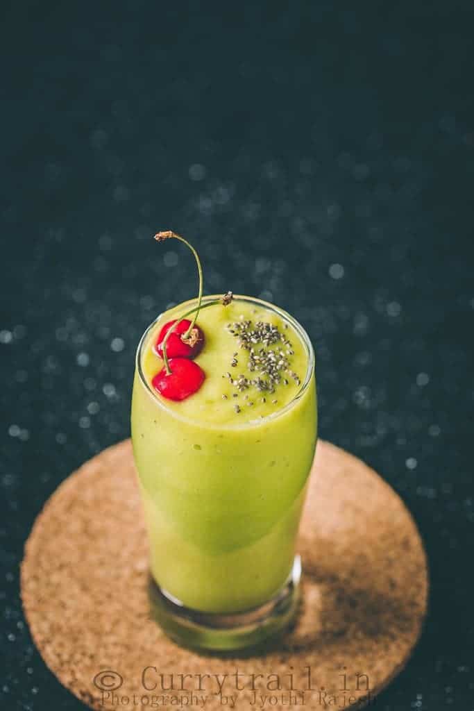 Healthy avocado banana smoothie topped with chia seed and fresh cherries