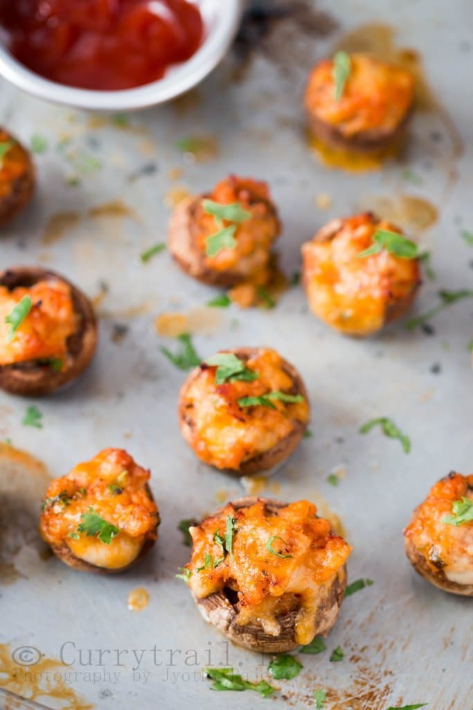 A platter of one bite appetizers including deviled eggs, stuffed mushrooms, and bruschetta with vibrant toppings.