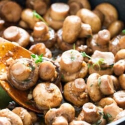 cooking sauteed mushroom recipe with butter garlic and thyme in skillet