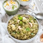 Homemade Mint Pulao in white bowl with raita on the side
