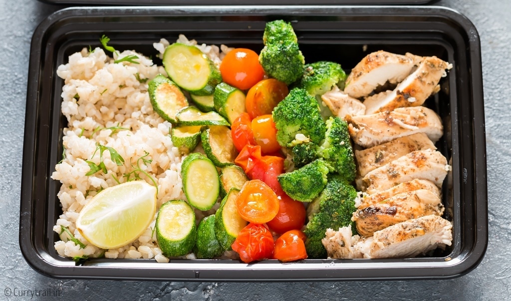 closeup of chicken meal prep with brown rice in meal prep boxes