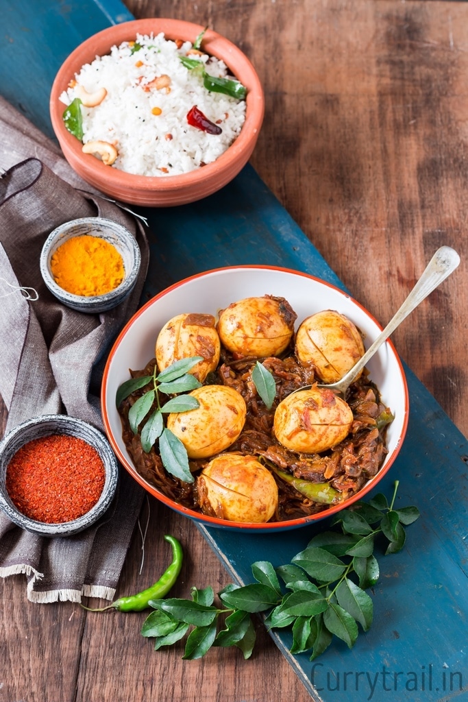 Kerala Style Egg Roast with spice bowls on sides