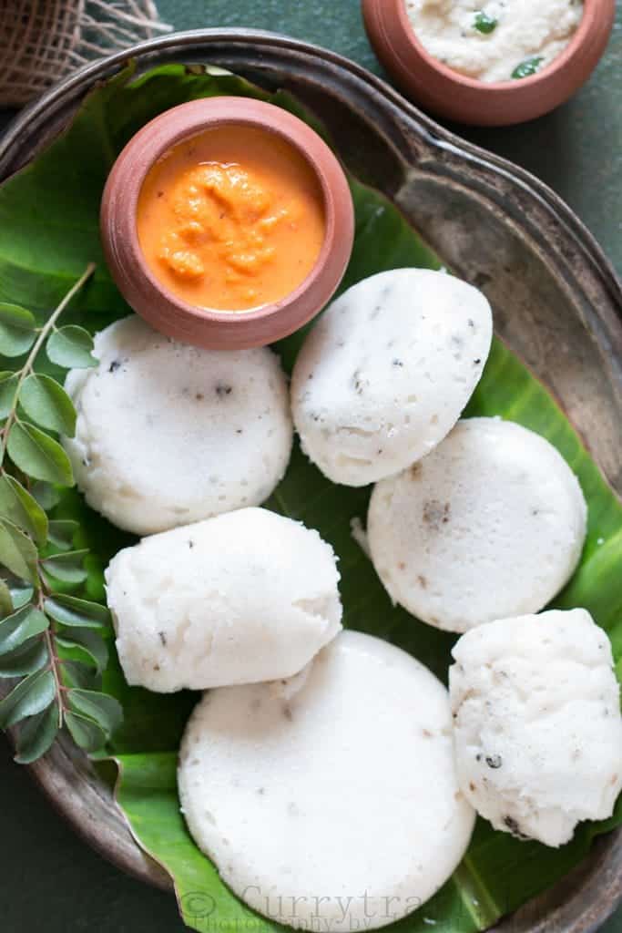 Kanchipuram Idli arranged on a oval plate with onion-tomato chutney on the side