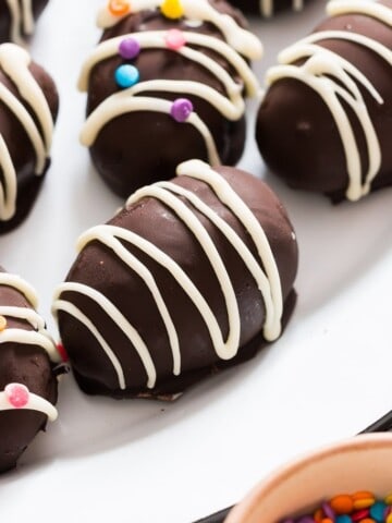 Close up of no bake OREO truffle egg with white chocolate drizzle