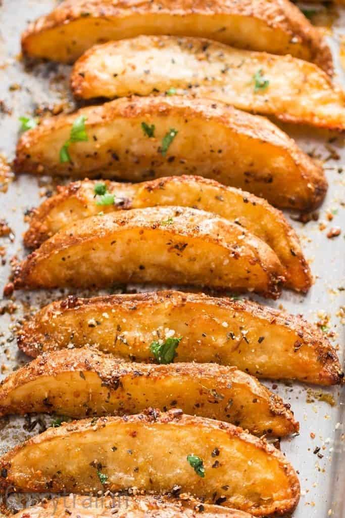 crispy baked garlic Parmesan potato wedges on a baking tray.