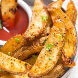 crispy potato wedges baked in the oven served with ketchup.