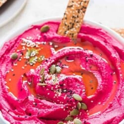 roasted beet hummus in a white bowl with cracker