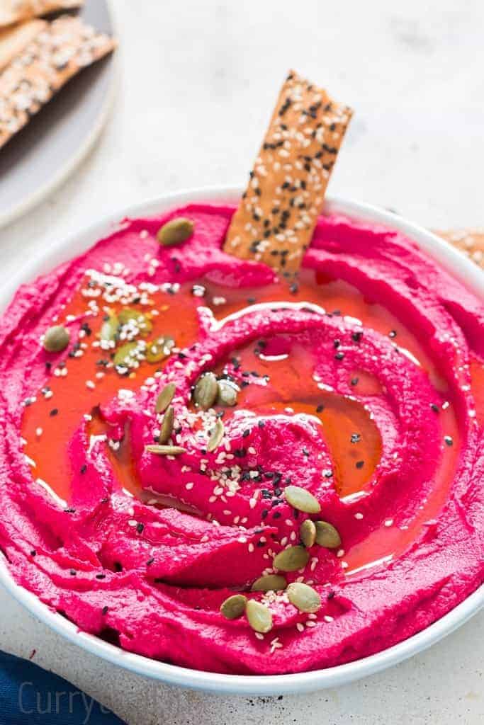 Beet-Hummus-41 roasted beet hummus in a white bowl with cracker
