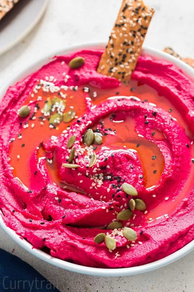 roasted beet hummus in a white bowl with cracker