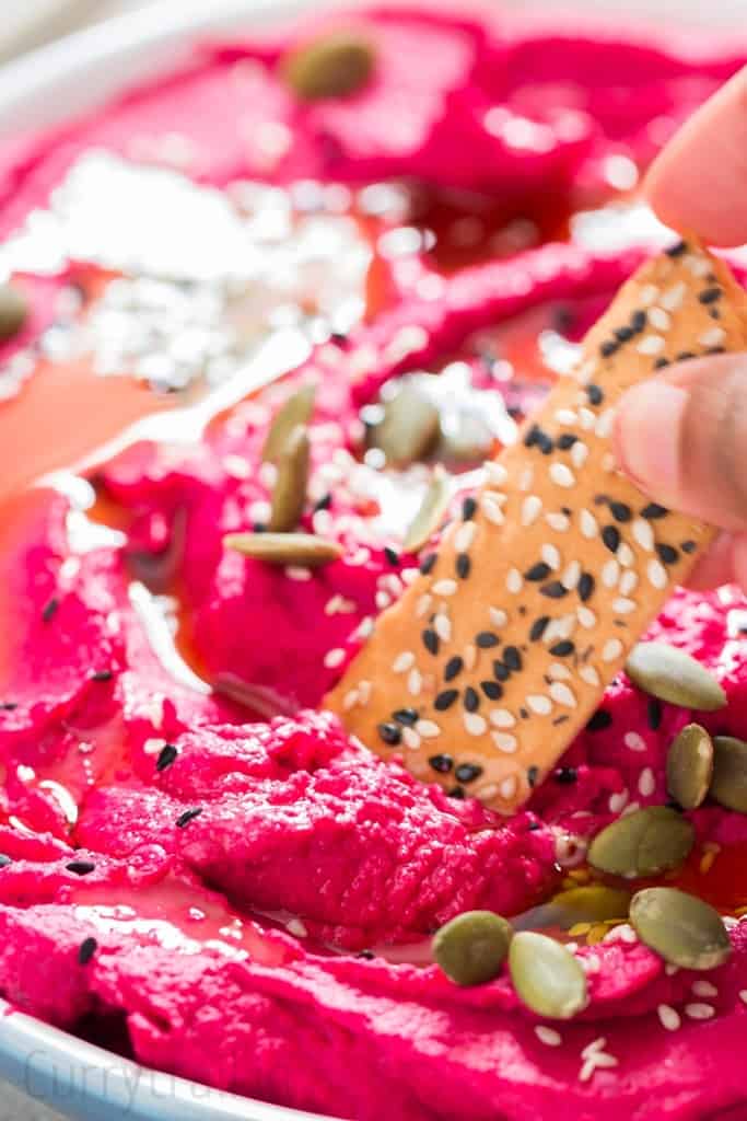 cracker scooping roasted beet hummus