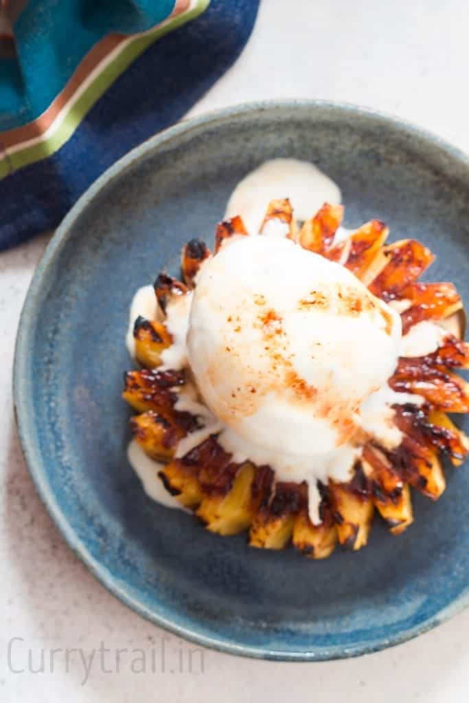 Vanilla ice cream melting over grilled pineapple drizzled with rum brown sugar glaze