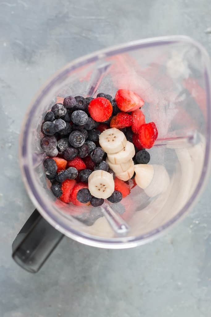 Frozen mixed berry smoothie in a blender.