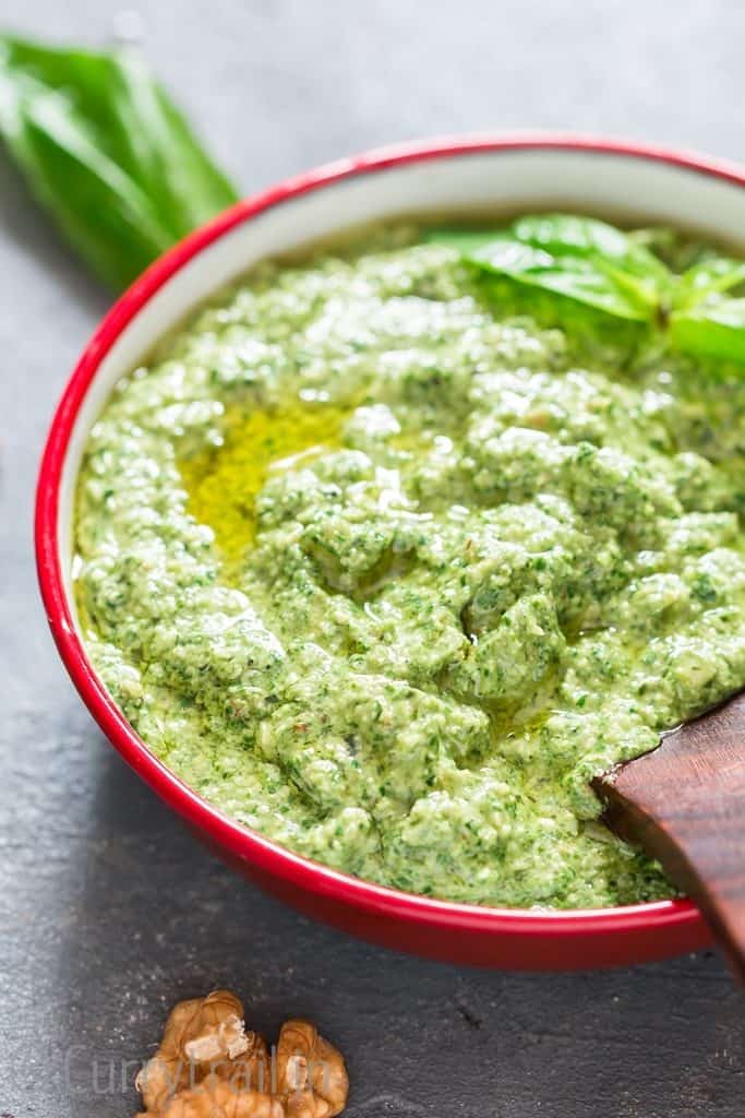 Basil Walnut Pesto in a bowl with wooden spoon